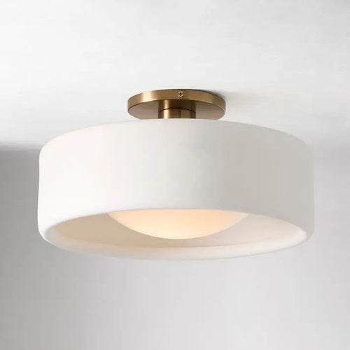 white flush mount light, brass base, warm glow